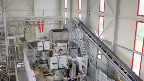 Wide view of the Centro Uno production hall in Full-Reuenthal, with fragmentation modules in the foreground and the inclined conveyor leading up to the next stage.